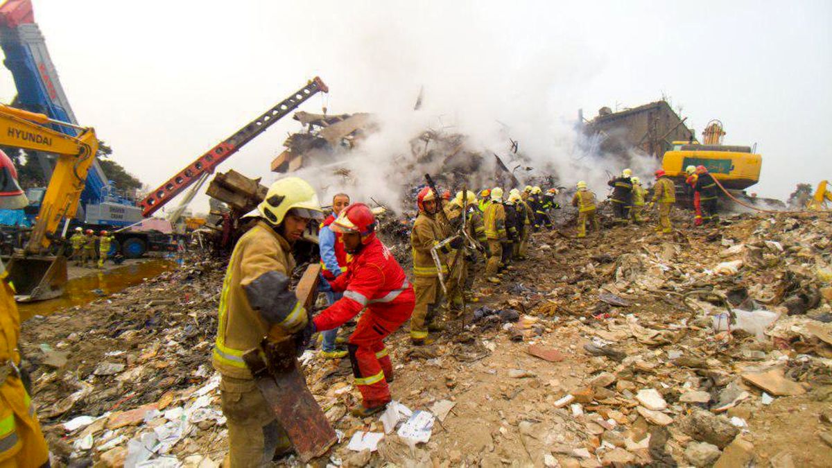 عکس: زنجیره انسانی آتش‌نشانها برای آوار برداری