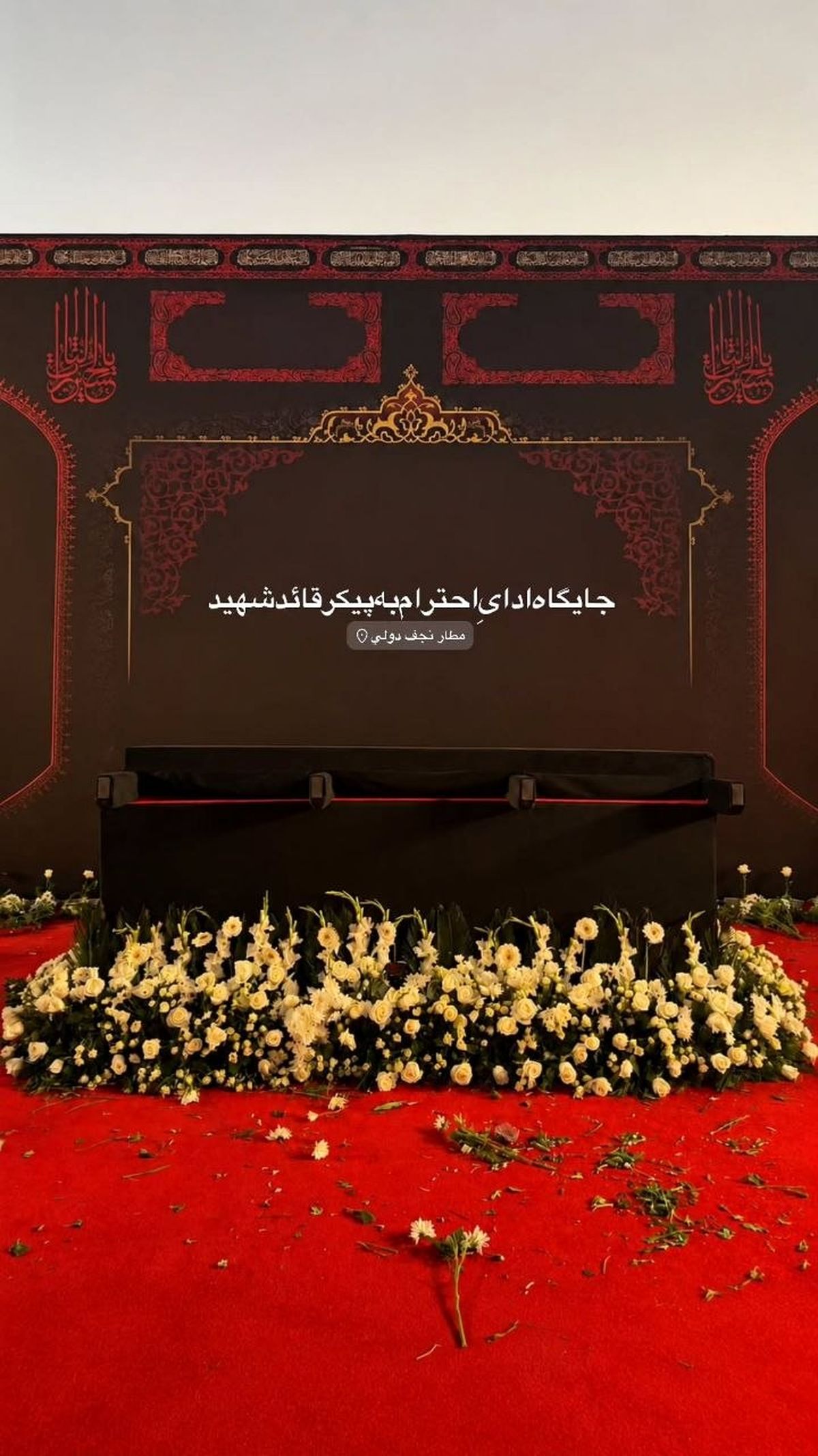 عکسی از جایگاه ادای احترام به پیکر قائد شهید در فرودگاه نجف اشرف