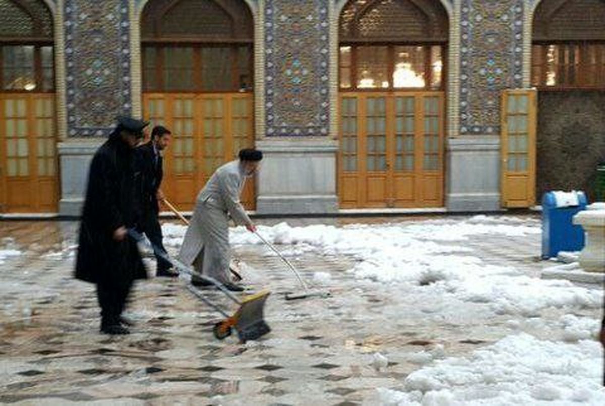 تصویری از برف‌روبی‌ صحن مطهر حرم امام رضا(ع) در کنار خادمان، توسط خادم‌الرضا(ع) شهید رئیسی - زمستان ۱۳۹۵