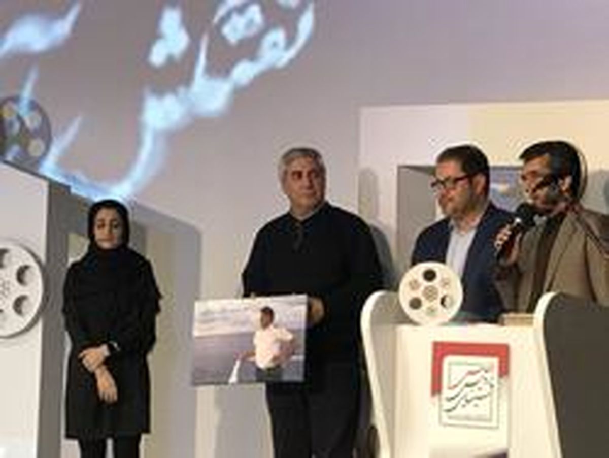 عکس شهید حادثه سانچی در دست حاتمی‌کیا